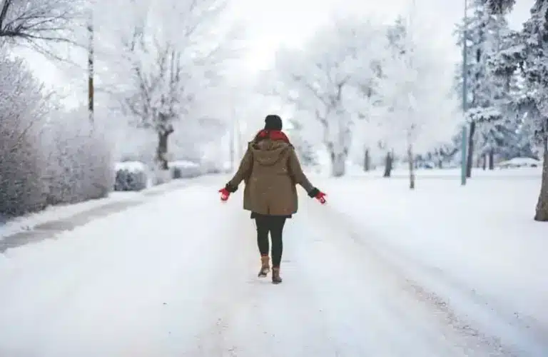 Person walking on a snowy street, winter walking