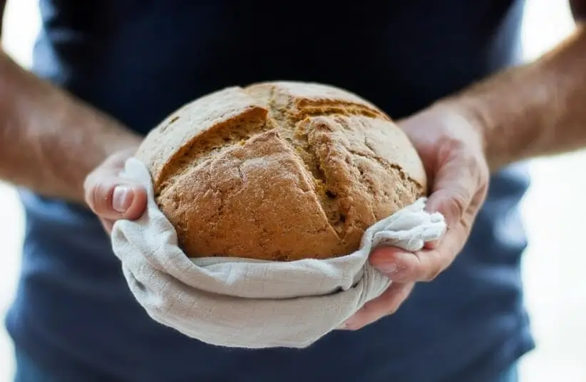 Man holding bread in a giving gesture, churches, holiday outreach, gluten-free, thanksgiving