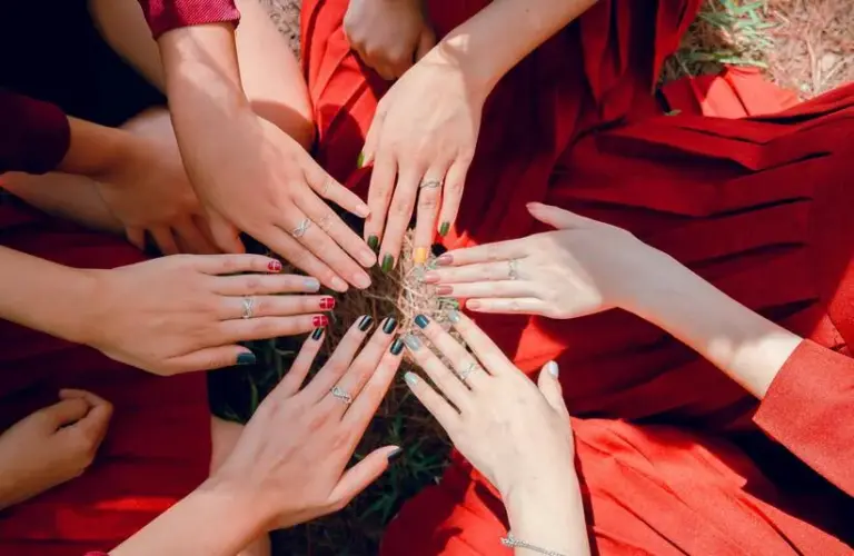 people in a circle with their hands together showing off their nails, thanksgiving nail trends