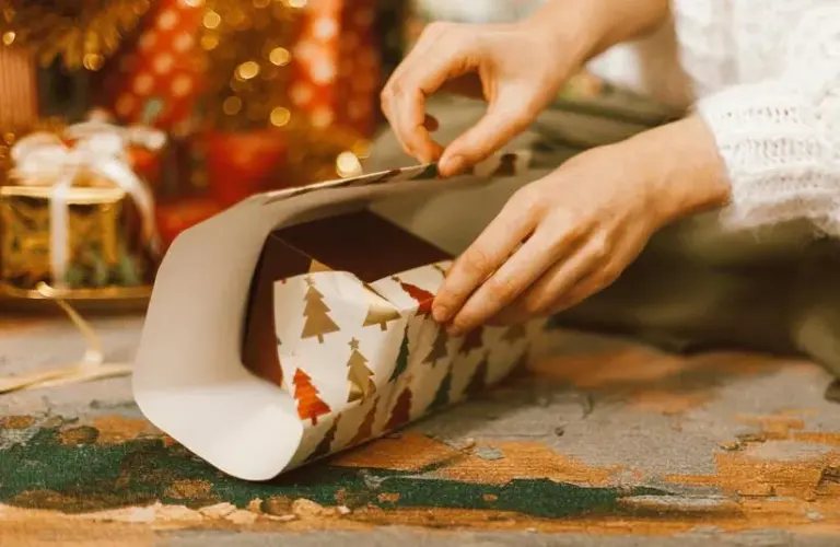 A person wrapping a gift, low-cost gift ideas for the holidays