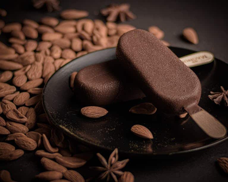 Rich almond and chocolate ice cream bars on a dark plate with whole almonds. Häagen-Dazs, recall on ice cream bars.