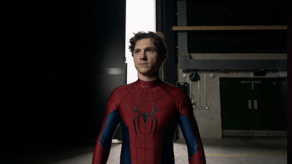 A person in a Spider-Man costume stands confidently in a dimly lit industrial space. Their expression is focused, embodying a heroic vibe.