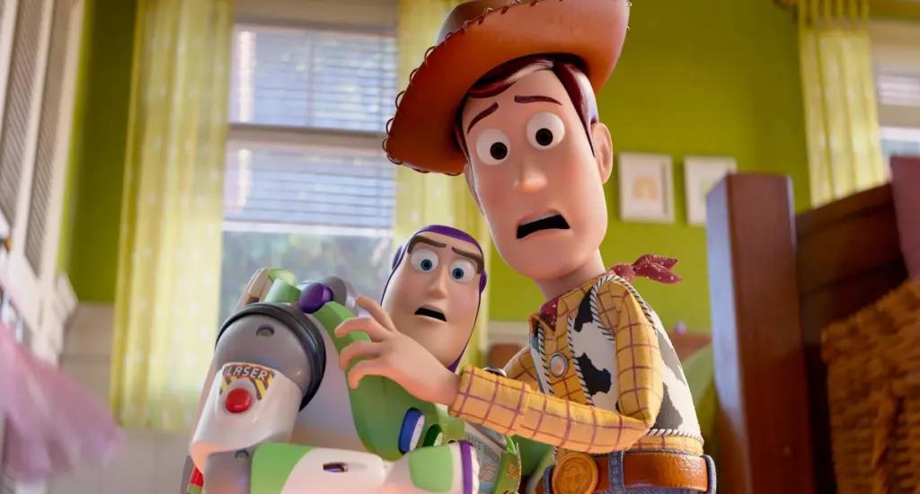 Woody and Buzz Lightyear from Toy Story 5 appear surprised and worried, standing close in a brightly lit room. The scene conveys urgency and surprise.