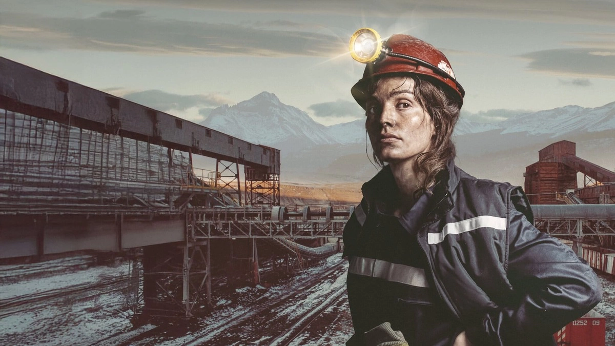 A determined miner wearing a headlamp stands in a snowy industrial landscape, surrounded by mountains. Text reads "Queen of Coal" in bold letters.