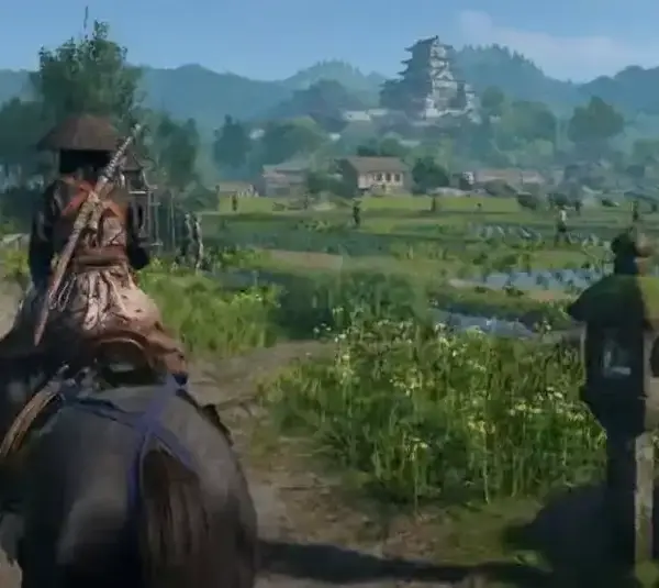 Assassin's Creed Shadows samurai rides on a horse down a rural path, surrounded by lush fields and distant mountains.