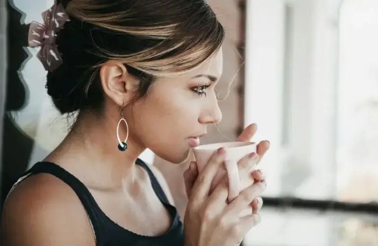 Woman drinking from a white mug, tea, spearmint tea,