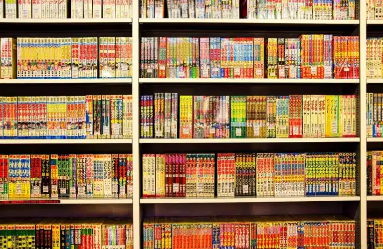 Bookshelf lined with colorful manga volumes in Japanese, organized neatly in rows. Vibrant covers create a lively and inviting atmosphere. Free Comic Book Day 2026