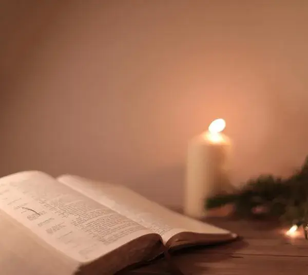 Bible open on a table with a candle beside it, Daily Devotion, candlelight