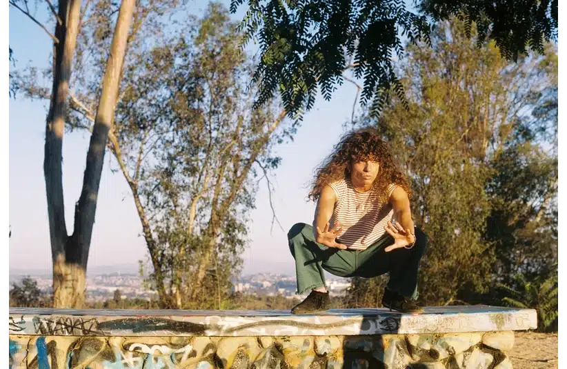 PR photo of indie-pop artist Arlie outdoors in a wooded area