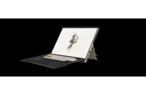 A sleek laptop with a detachable keyboard is displayed against a black background. The screen shows a digital sketch of a stylized human face. Image courtesy of KOJIMA PRODUCTIONS Co., Ltd./HIDEO KOJIMA and ASUSTeK Computer Inc.