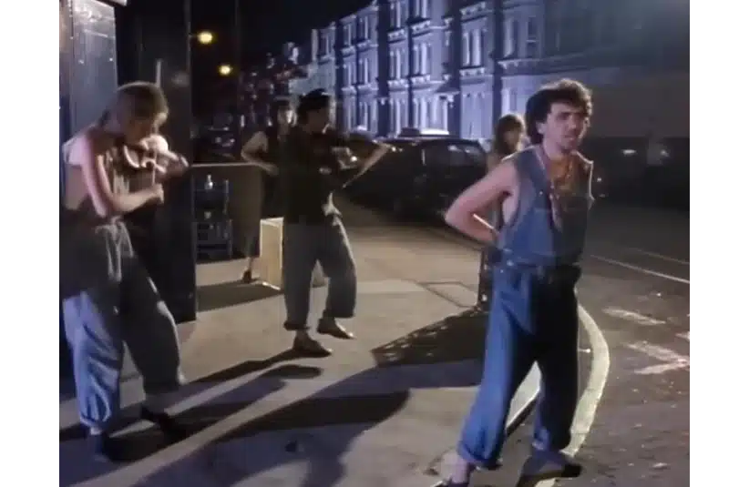 Dexys Midnight Runners perform "Come On Eileen" on a street corner in a music video for the song.