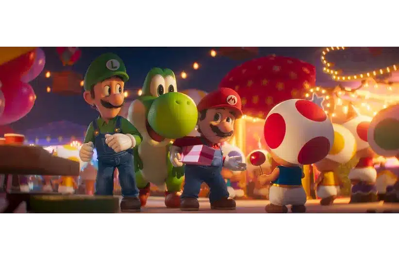 Mario, Luigi, Yoshi, and Toad joyfully walk through a festive, brightly lit market. Mario holds a gift, while Toad offers a red lollipop in The Super Mario Galaxy Movie