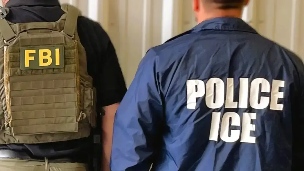 Two law enforcement agents in a hallway, one wearing an FBI vest and the other in a jacket labeled 'Police ICE,' suggesting collaboration or operation.