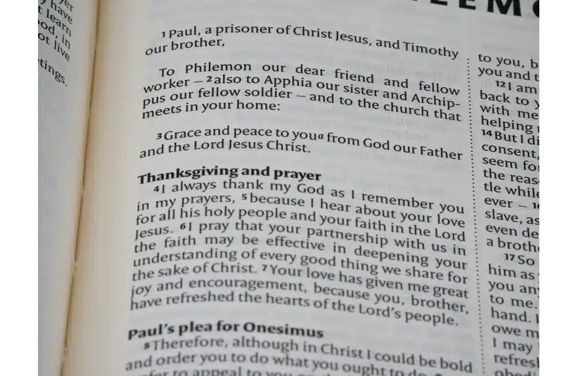 Open Bible page showing verses from the Book of Philemon. The text discusses grace, peace, Thanksgiving, and prayer, conveying a serene and reflective tone.