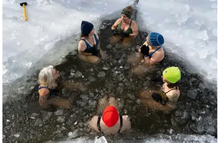 A group of people sitting around as they participate in cold plunging