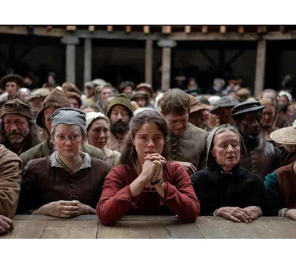 Jessie Buckley as Agnes, watching a Shakespeare play in Hamnet, which is nominated for sux Golden Globes.