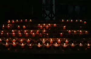 A warm cluster of lit candles glowing in a dark room, symbolizing the light and hope of Candlemas.