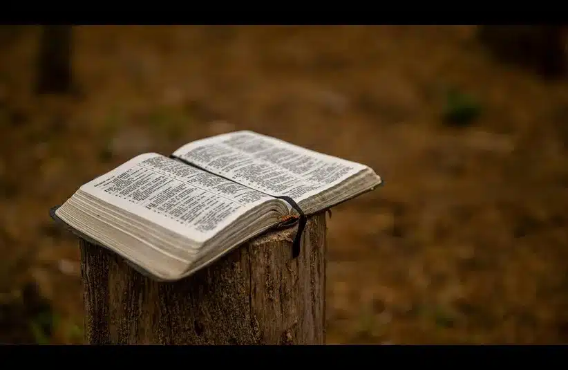 In daily devotion, an open Bible is outside sitting on a post, maybe open to Exodus.