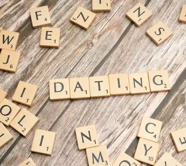 Scrabble tiles spell "DATING" on a wooden surface, emphasizing clarity dating