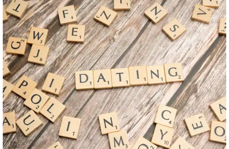Scrabble tiles spell "DATING" on a wooden surface, emphasizing clarity dating
