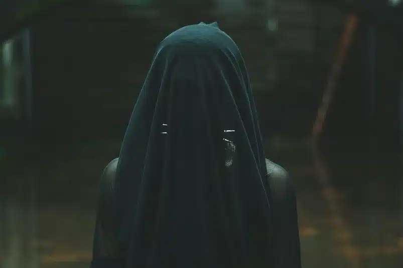 In the daily devotion, a woman is covered in black with a veil included.