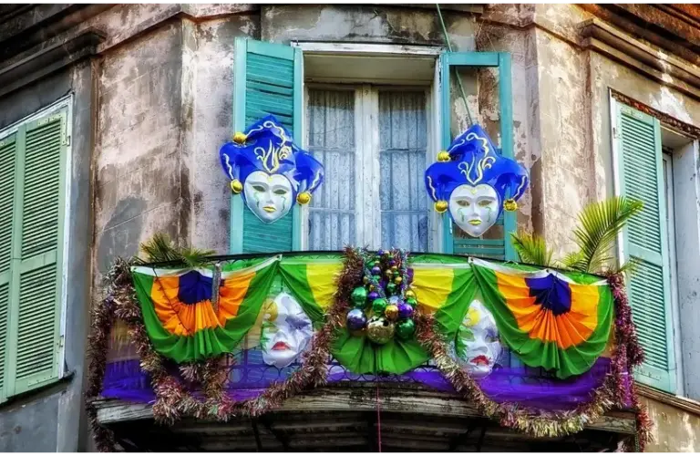 Old building balcony with colorful Mardi Gras decorations, featuring masks and garlands in green, purple, and gold. Festive and lively atmosphere, Fat Tuesday, Shrove Tuesday
