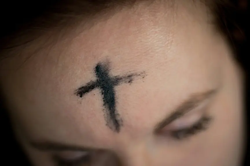 A person with ashes forming a cross on their forehead for Ash Wednesday