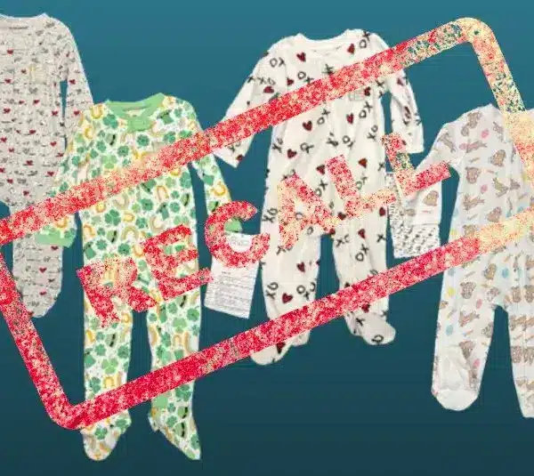 Four children's pajamas with various colorful patterns on a teal background are overlaid with a bold red "RECALL" stamp, indicating a product recall.