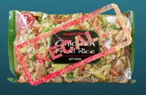 Packaged Trader Joe's Chicken Fried Rice against a blue background. A large red "RECALL" stamp overlays the image, indicating a recall notice.