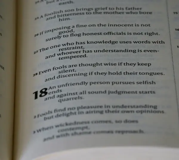 Open book showing a passage with numbered verses. Verse 18 appears bold, discussing themes of wisdom, restraint, and understanding. Calm tone. the ten commandments