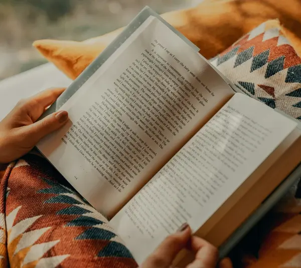 Person reading a book (possibly one of the best sellers)