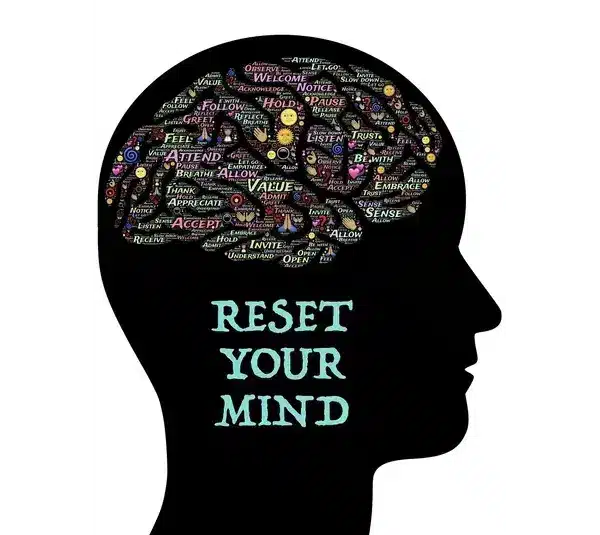 Silhouette of a head filled with positive words like "value" and "trust" in vibrant colors. Below, the text reads "Reset Your Mind" in light blue for visualization.
