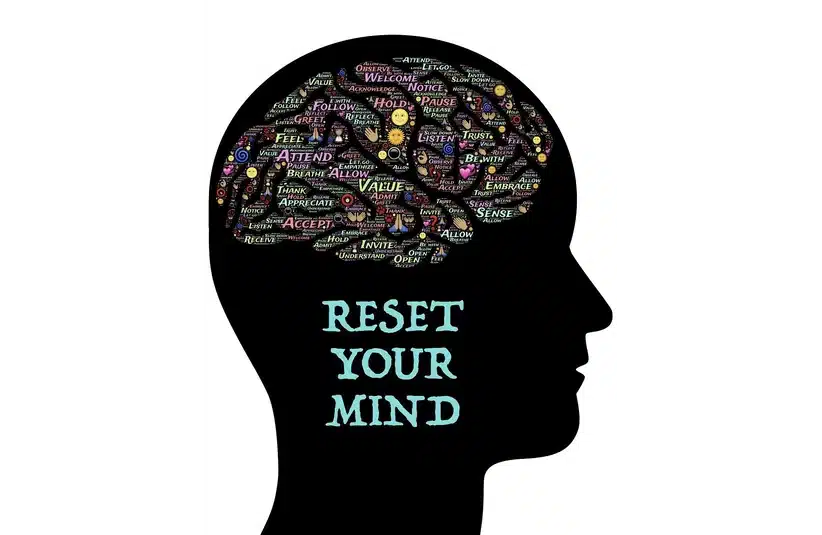 Silhouette of a head filled with positive words like "value" and "trust" in vibrant colors. Below, the text reads "Reset Your Mind" in light blue for visualization.