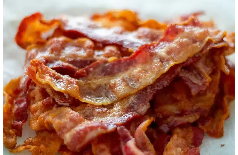 Layers of crispy, cooked bacon stacked on top of each other