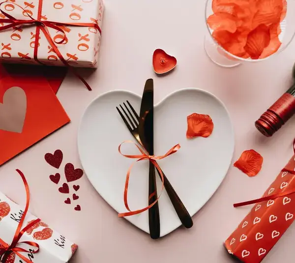 valentine dinner table with heart shaped plate and small red gifts