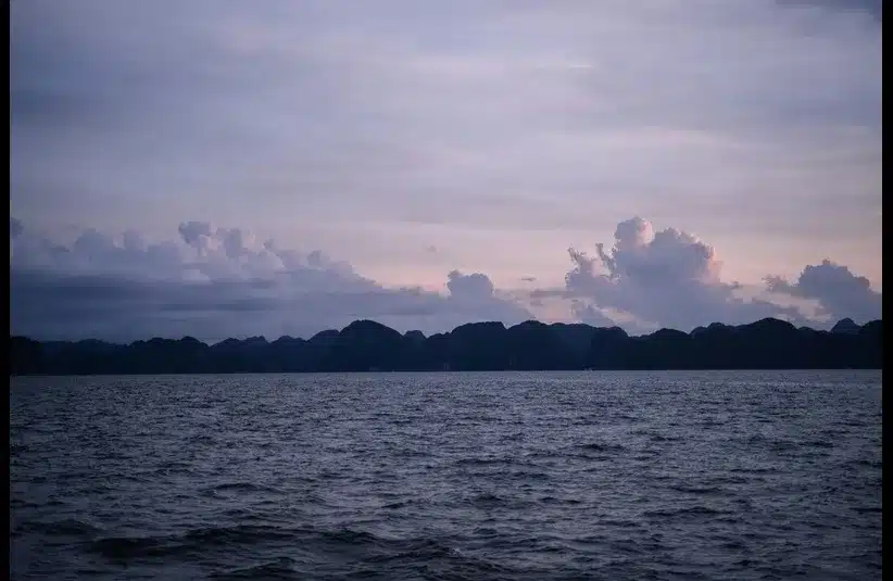 In daily devotional, a peaceful scene of water and sunrise is on the horizon.