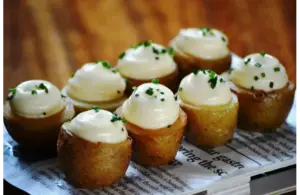 Potato appetizers with garlic mayo on a platter.