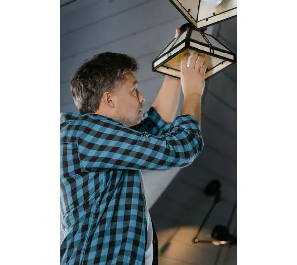 A person fixing a lamp in his home