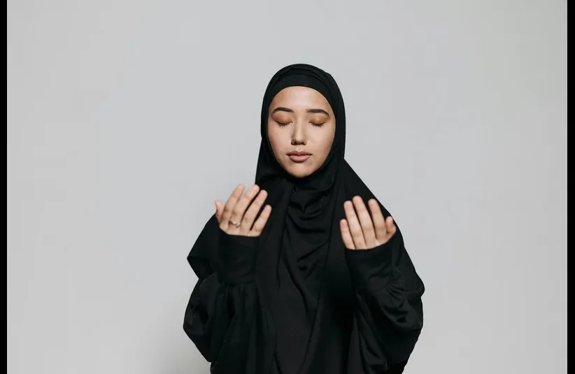 In daily devotion, a woman expresses faith in God.