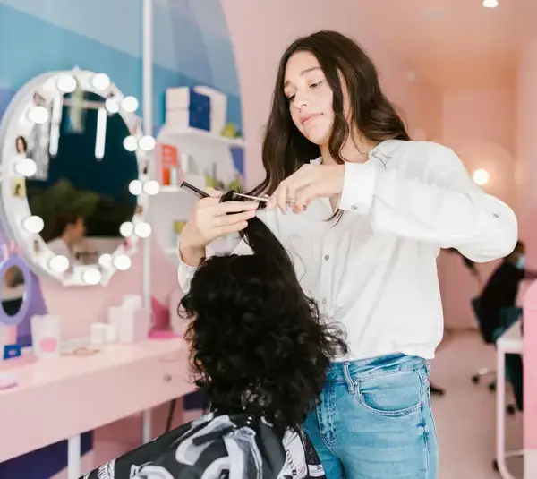 a girl performing a haircut in a salon