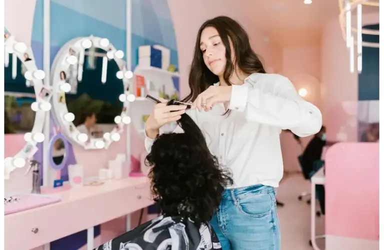 a girl performing a haircut in a salon