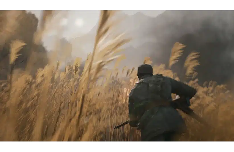 Soldier running through tall grass