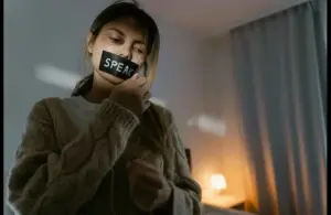 A woman removing the black tape on her lips, similar to the Turpin family case