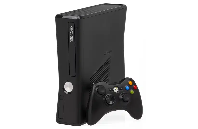 Black Xbox 360 with black Xbox controller leaning against it