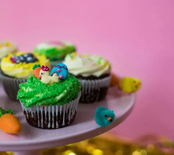 A tray of cute and bright Easter-themed cupcakes