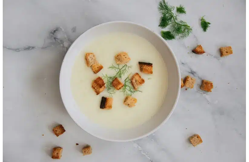 A bowl of delicious soup with fresh herbs and croutons