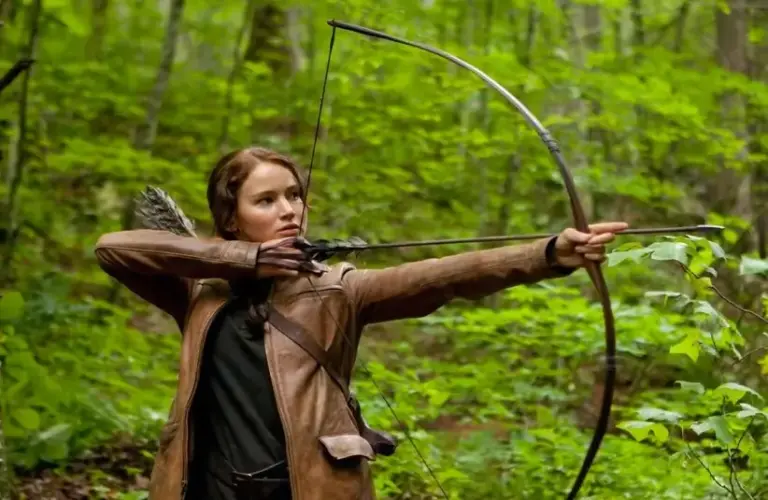 Katniss raises her bow in the sci-fi film The Hunger Games