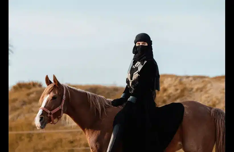 In daily devotion, a woman sits on a horse.