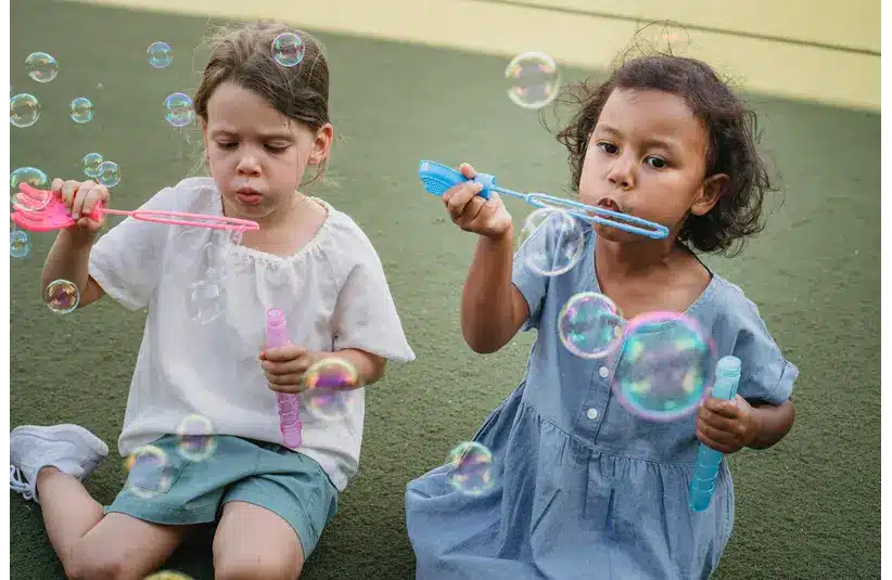 Two children playing with bubbles