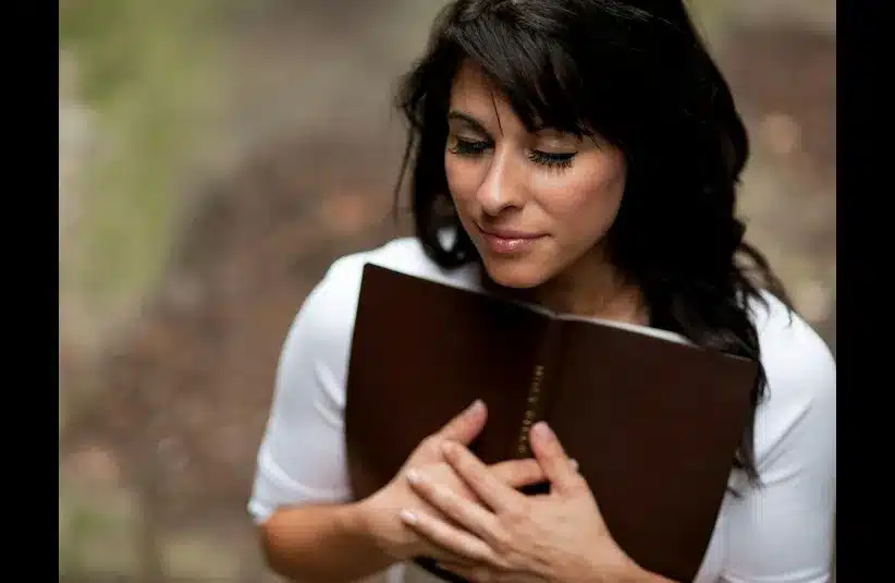 In daily devotion, a woman embraces the Bible.